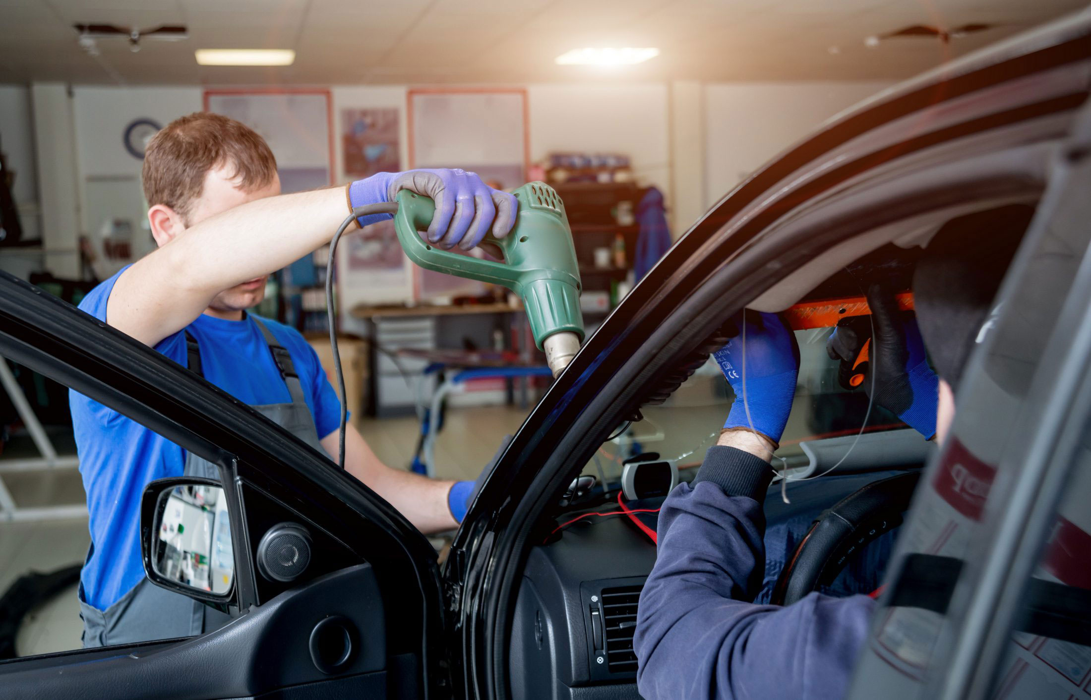 Technician inspecting a finished windshield installation