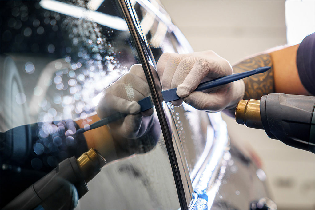 Technician replacing a shattered driver's side window on an SUV in Ottawa